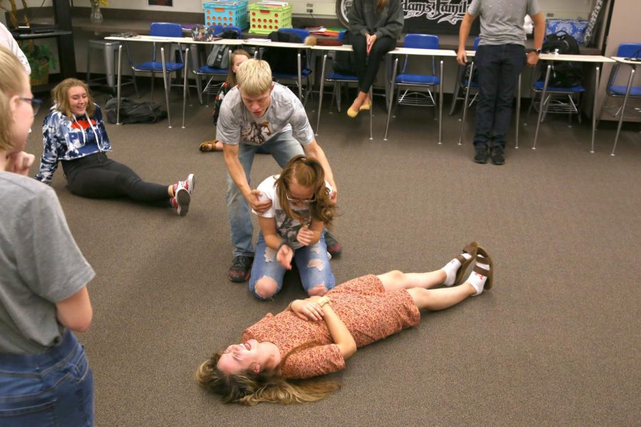 FREEZE! Zeke Kemp takes a firm hold on Sam Meyer while Trinity DeJournet lies on the ground during an improvisation game called Freeze in drama class.