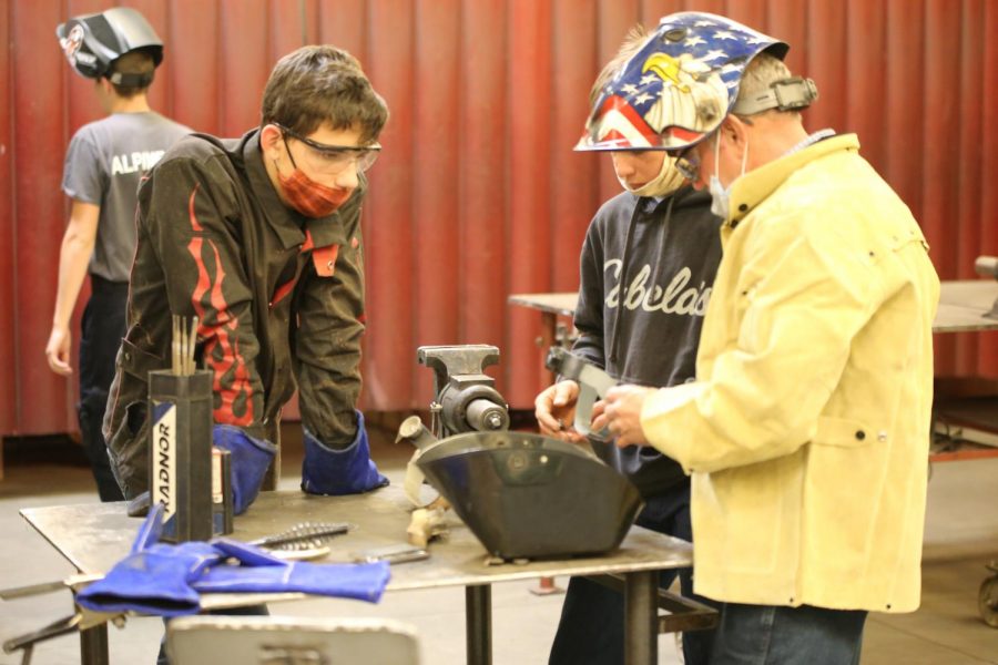LET ME SHOW YOU: Mr. Warren doing what he has done for 30 years, helping kids like Josh Baird learn tradecraft. “Welding has also played a major role in my teaching, and I still get excited when I see the look on a student’s face that says, I get this, I can weld, said Warren. 