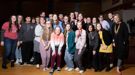 TEAM: Speech & Debate members pose proudly in the spotlight after their competition. My favorite part was probably just spending time with the team. It was just a really cool experience, said sophomore Maggie Daniels.
