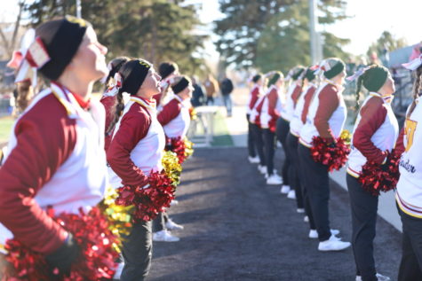 MUFFLED: The cheerleaders, in their matching uniforms and ear warmers, get ready to march in the homecoming parade. 