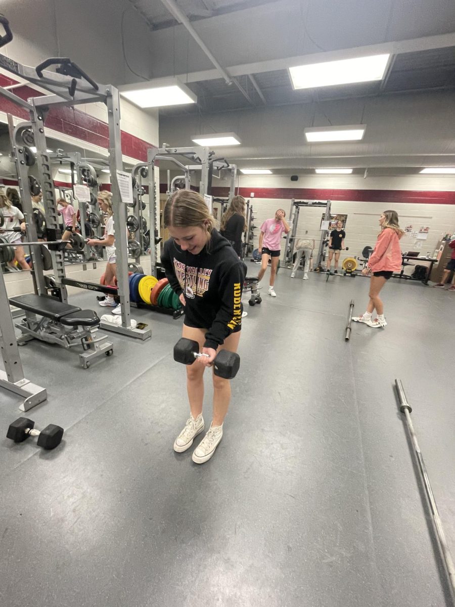 CURLS ON FIRE: During 6th hour weights, junior Hallie Robertson uses a dumbbell to complete a set of curls. Currently, 31 girls are participating in this trimesters two classes. Curls really help to define your biceps, explained Robertson. 