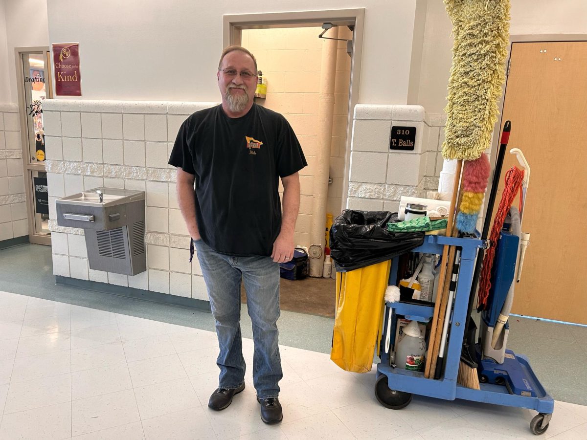 MR. CLEAN: Custodian Todd Welker stands in one of his halls. Welker not only keeps his areas of the school spic and span, but also tells dad jokes to people each day. What do you call 2 birds stuck together? Velcrows. 