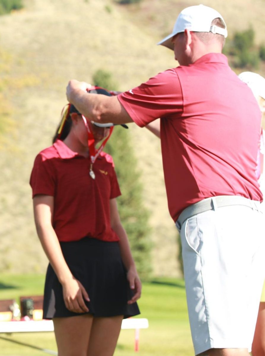 CROWNED: Mr. Jason Horsley slips the champion medal onto the neck of his daughter Jordyn after she won the 4A state golf tournament. Horsley was the first SV female golfer to win the title since 2006. 