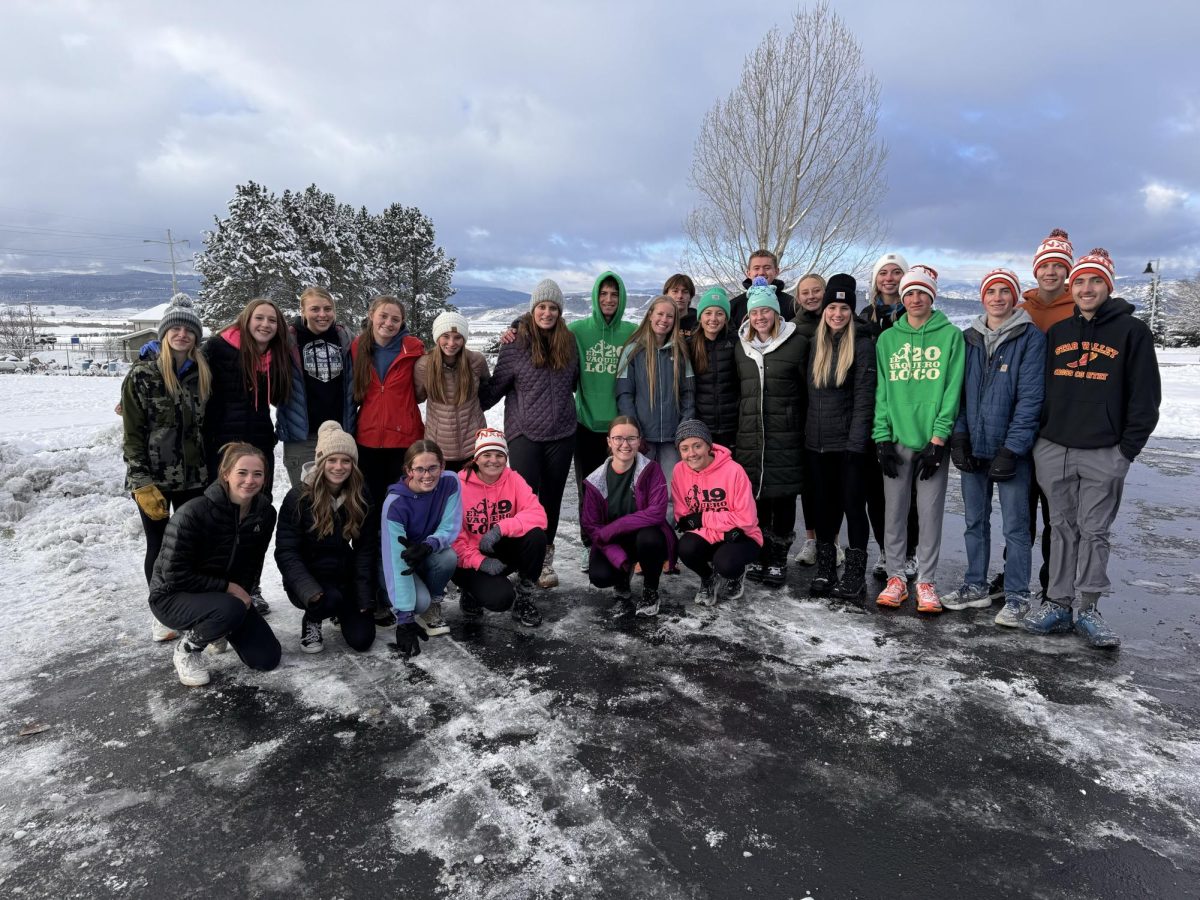 The cross country team gathers to serve during Braves in Action. The team showed up at Afton Elementary and Etna Elementary to help the kids run in their annual Turkey Trot and cheer them on while running. 