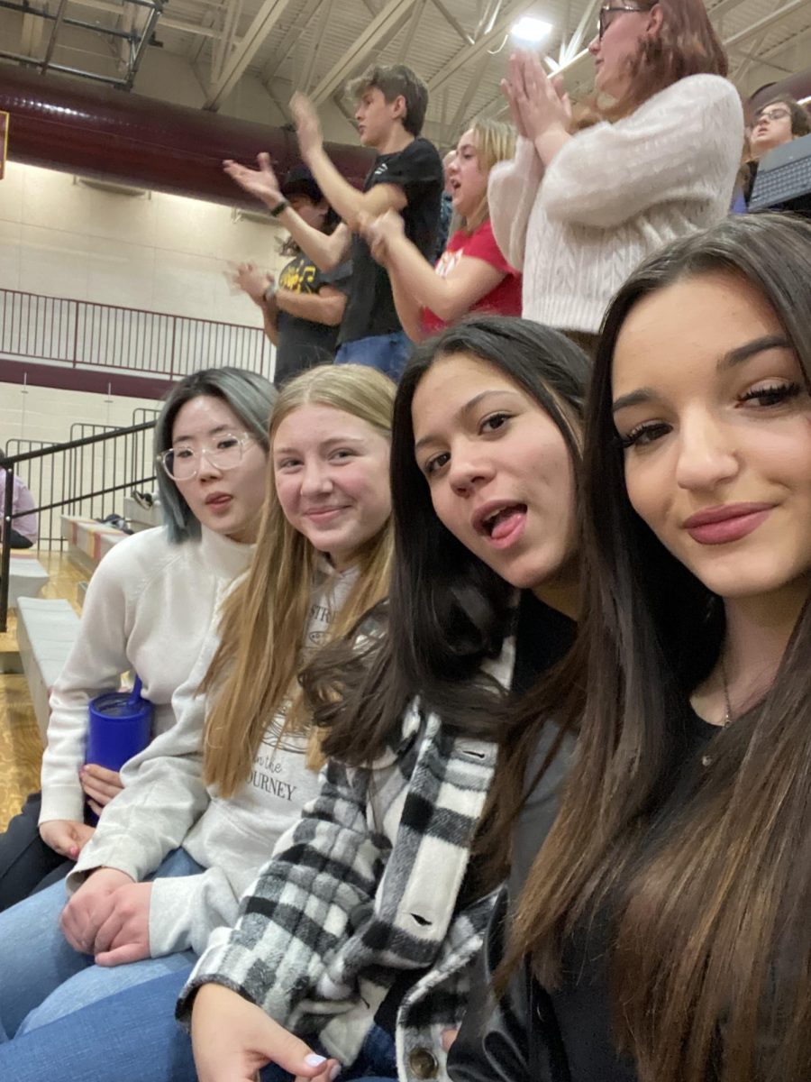 South Korean exchange student Ahrin Kim and Italian exchange Anna Formisano join Sammy Moffat and Koral Arnold at a basketball game. This was their first time in the students section, but not their last. They said, "We go to all of the basketball games."