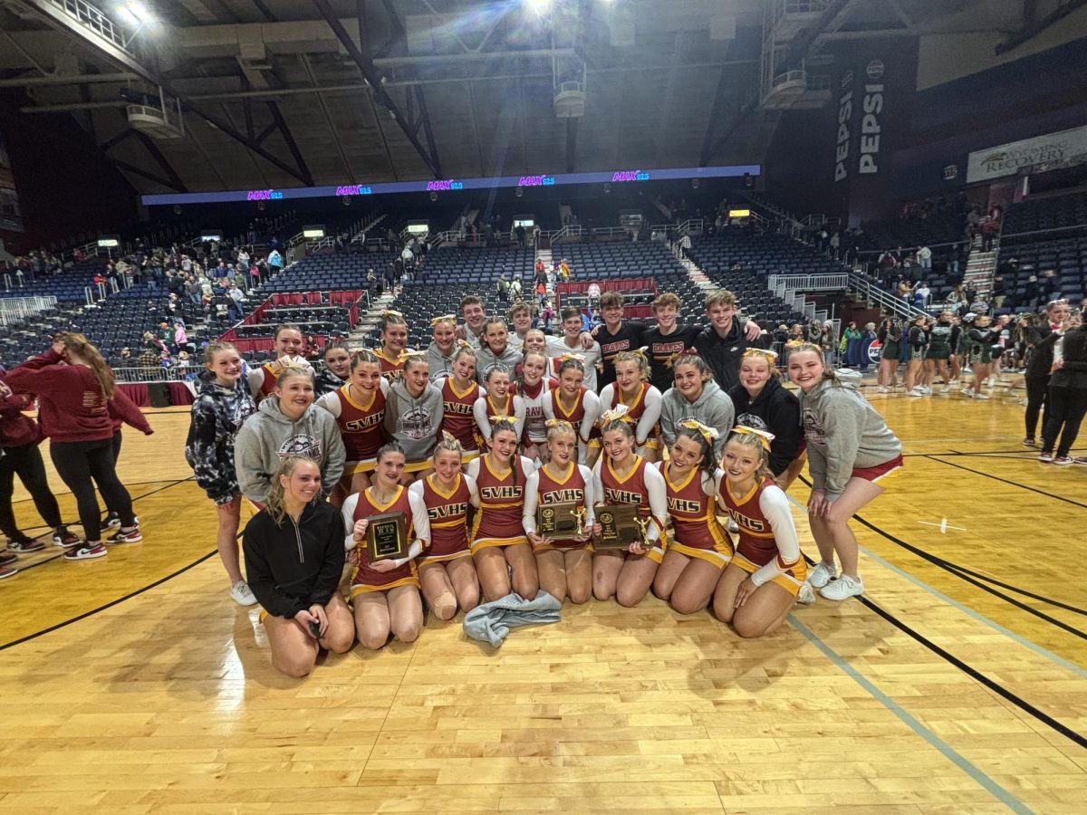 The cheerleaders take one last picture all together as a state team after hearing their final scores at the state competition. They are assembled on the floor that they just performed their routines on for the last time. "I was just trying to soak it all in because it was my last time competing ever and my last time doing those routines with my team, even if they didn't go as planned," said senior Lucy Strasburg. 