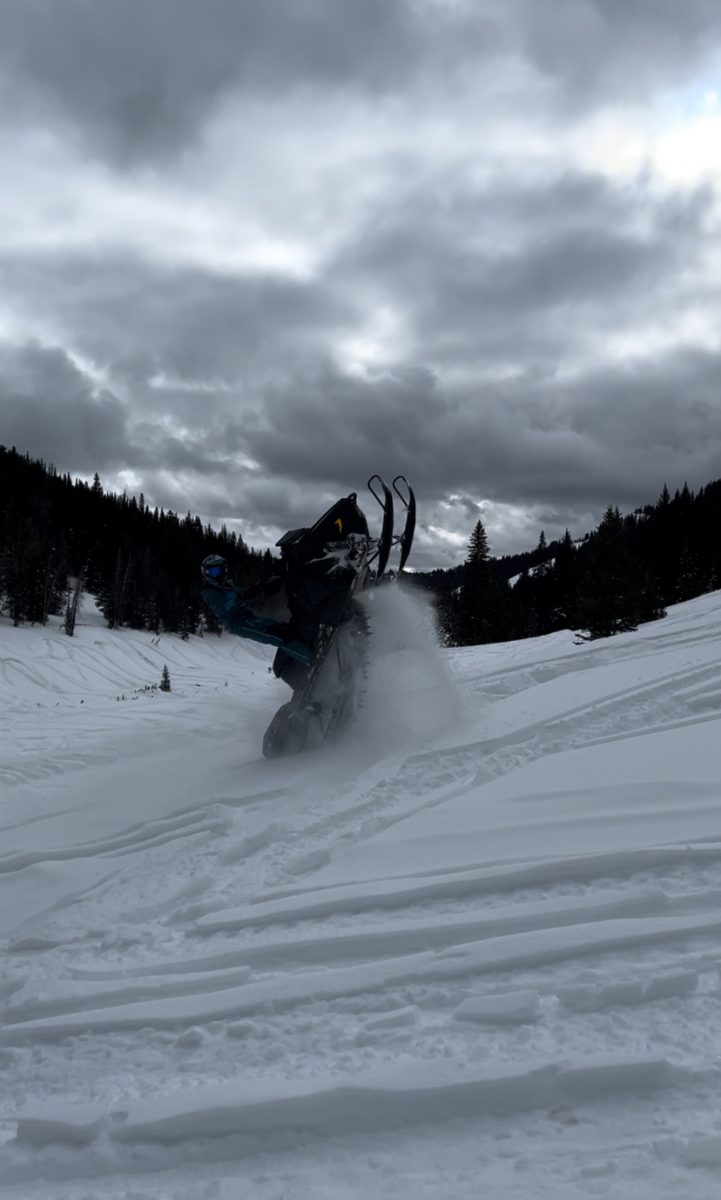 Quinn Simpson climbs up a trail in the Togwoetee mountain range. He and his friends try to go snowmobiling every weekend. "I just enjoy going outside and taking in the fresh air," said Simpson.