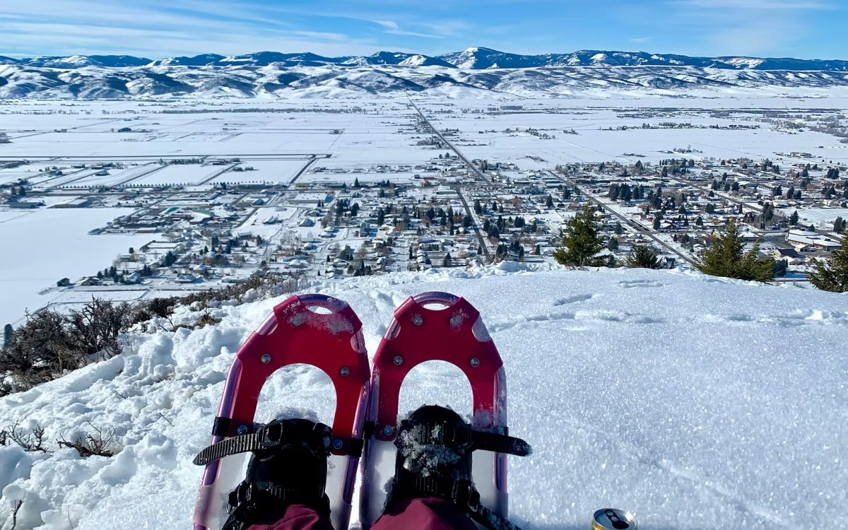 A snowshoer peaks over their shoes down to the town of Afton. Activities like this help residents enjoy winter. 