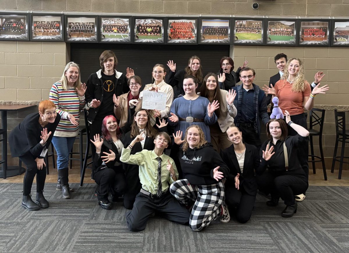 The Speech and Debate team poses to celebrate a former member's birthday. The Speech and Debate team is like a family for many members ,and they don't know where they would be without them. 