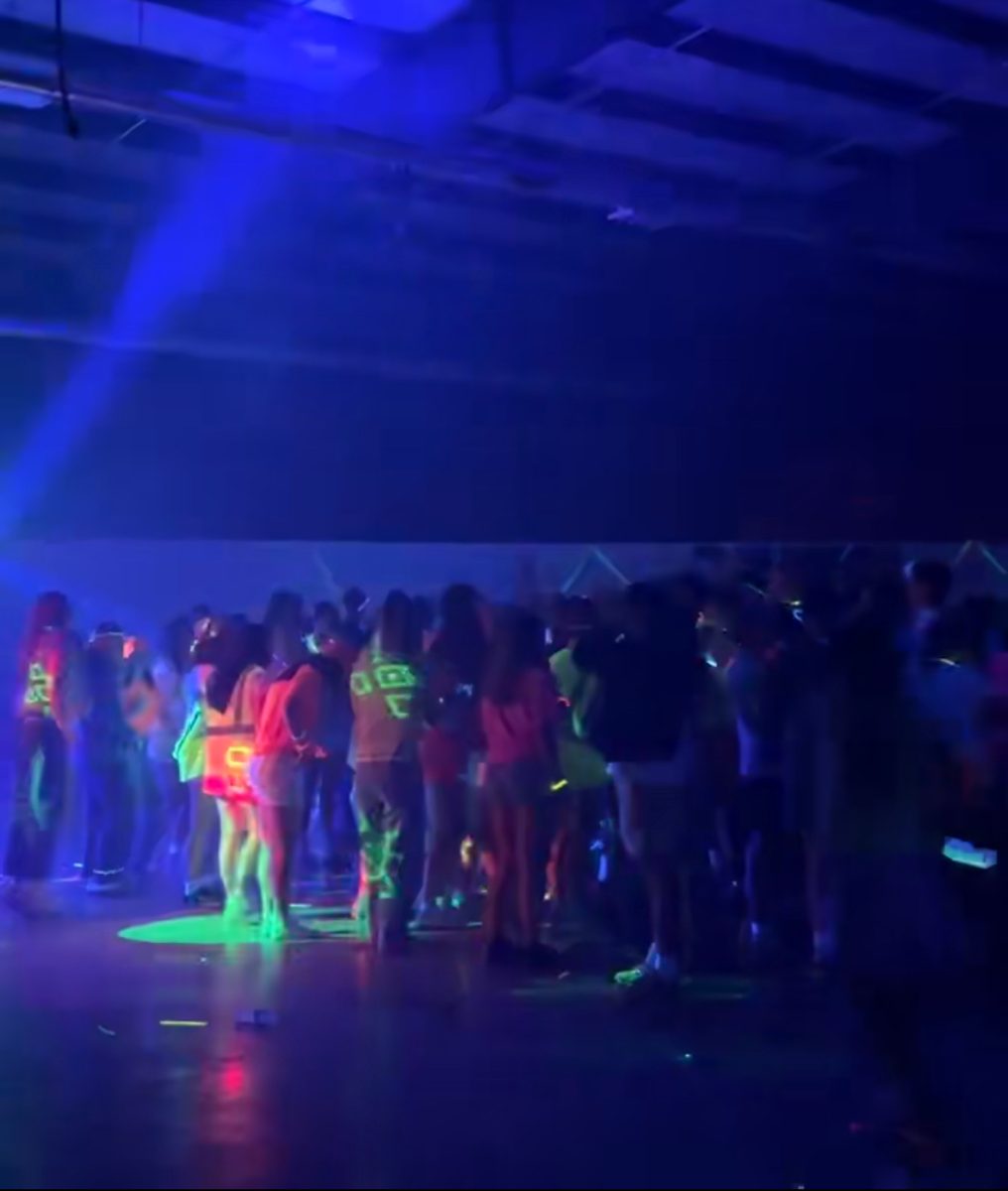 Highschool students from a bunch of different schools gather together in their neon at a community teen dance. A few weeks earlier many of them attended the Hawaiian-themed MORP dance. "Dances like this are the best. Nights like these are what I'm going to remember from highs chool," said freshman Kyli Hoopes.