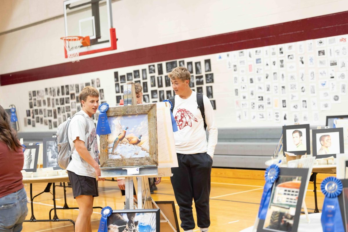 Dax Button, Crew Morgan, and Kai Frazier peruse the art on display from their classmates. The state art show was in the aux gym for 3 days showcasing hundreds of interesting, beautiful, and award-winning pieces. "It's fun walking around and seeing what's going in student's minds that they put down on paper," said Frazier. 