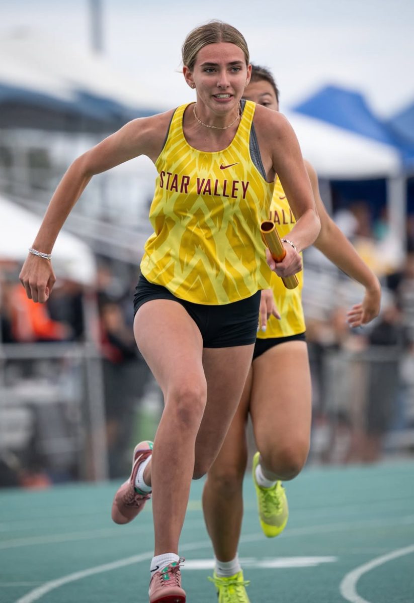 Kate Gaskell puts 100 percent effort into her relay race. She received the baton from teammate junior Arianna Foster. Gaskell said, "The most stressful part of the race is when you have to pass the baton off or receive it. Thankfully I've never dropped it."