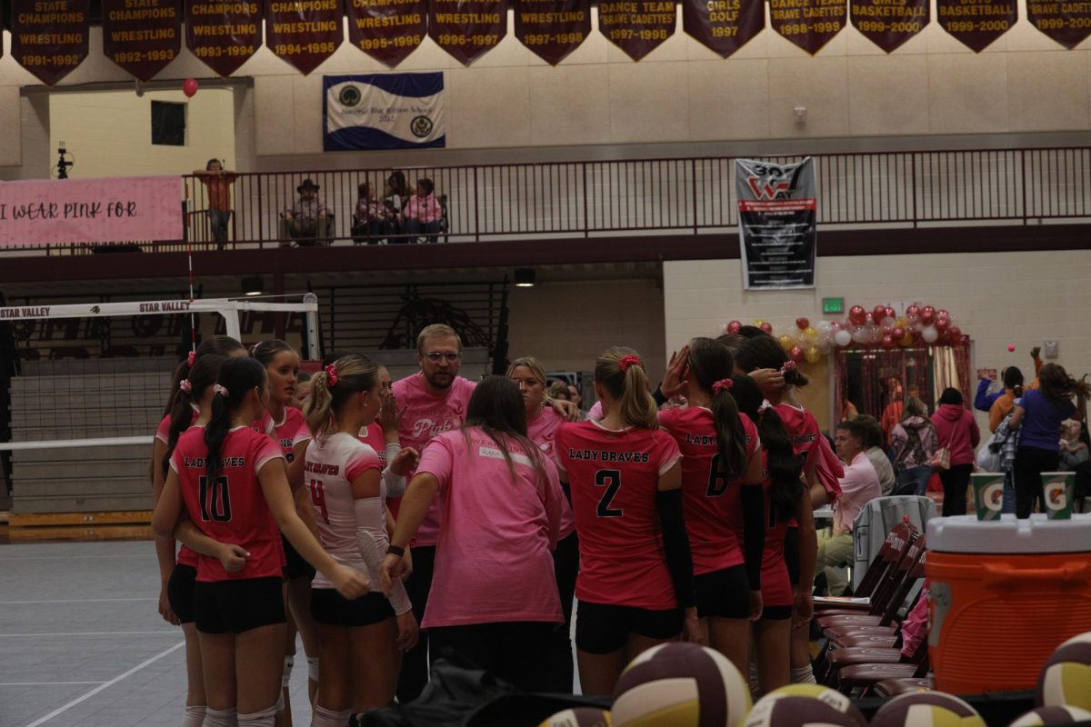 The Lady Braves huddle on during pink night and strategize their game plan.  Coach Kalin Schwab said, "I like our team huddles because they give us time to regroup and take a breathe so that we can go back out on the court and win." This is Schwab's first year as the Lady Braves' head coach.