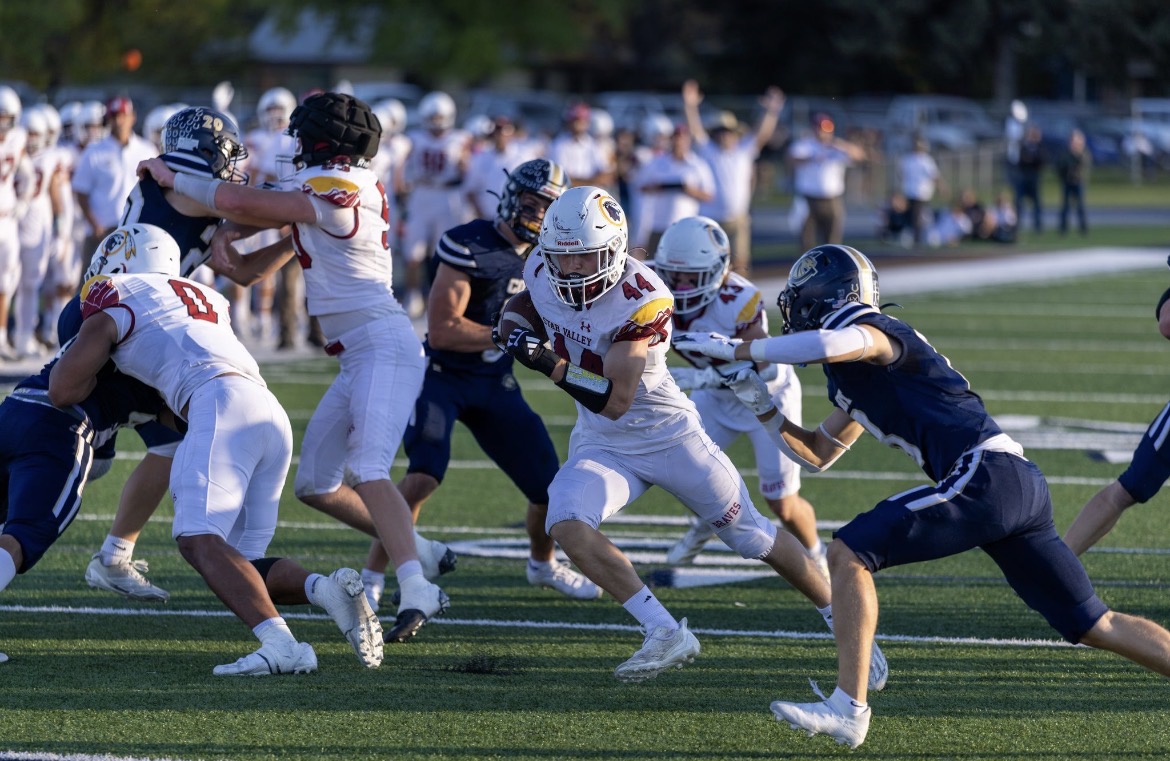 Junior Nate Haderlie weaves through traffic. Nate had one of the team's two touchdowns in a close win over Cody. "This is my first varsity year, so I'm just trying to give a full effort and contribute what I can," said Haderlie. 