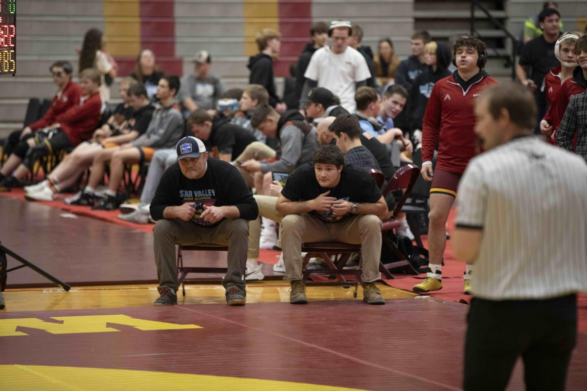 Coach Parry watches intently as his son Kimball goes for the win. Kimball and his brother Tel both won an individual state championship last year, and Kimball went up three weight classes for this season. Kimball said, "I am excited to dominate the competition."