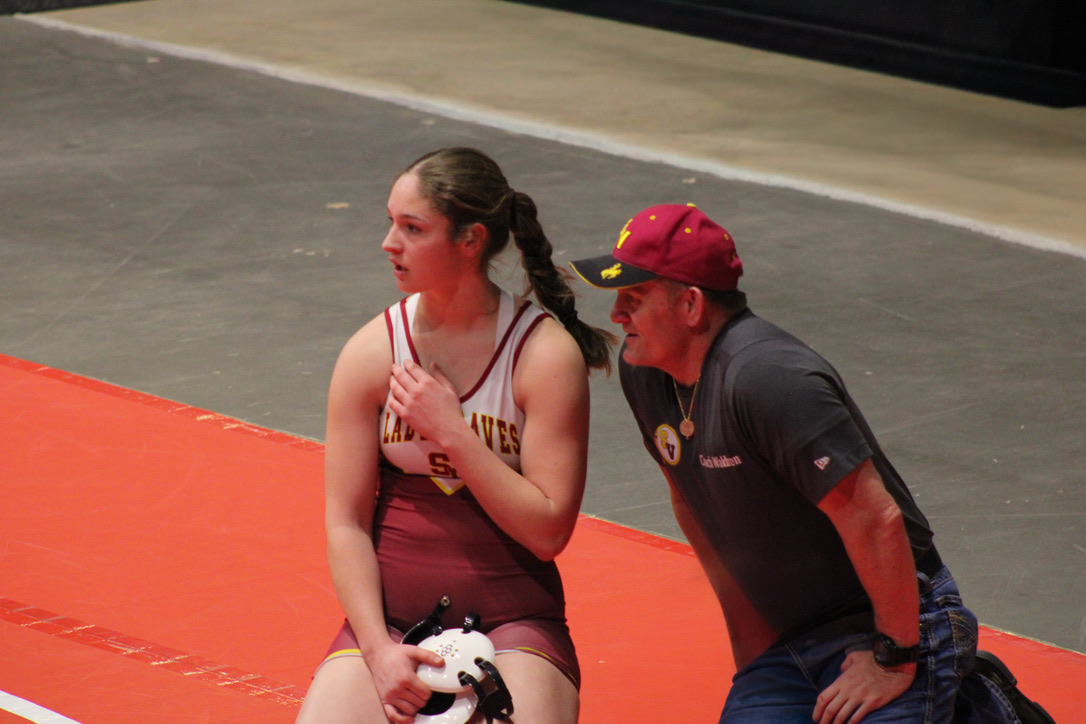 Senior Brooke Schwab talks to coach Waldron while resting between matches last season. Brooke finds endless challenge in her sport. "My favorite thing about wrestling is the ability to improvement in myself and my team! I love seeing how the work we put in gets executed when we compete."