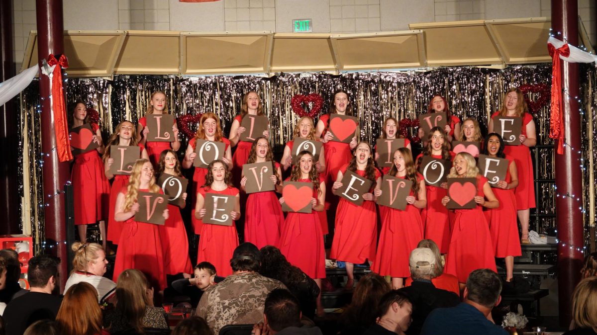 Treble Tones members hold signs spelling "LOVE" while performing their traditional opener, "L-O-V-E" by Michael Bublé. Sophomore Bella Casey said, "I love the opener because it's a Treble Show tradition and it ties the whole show together. It's a classy song, and it brings us all together."